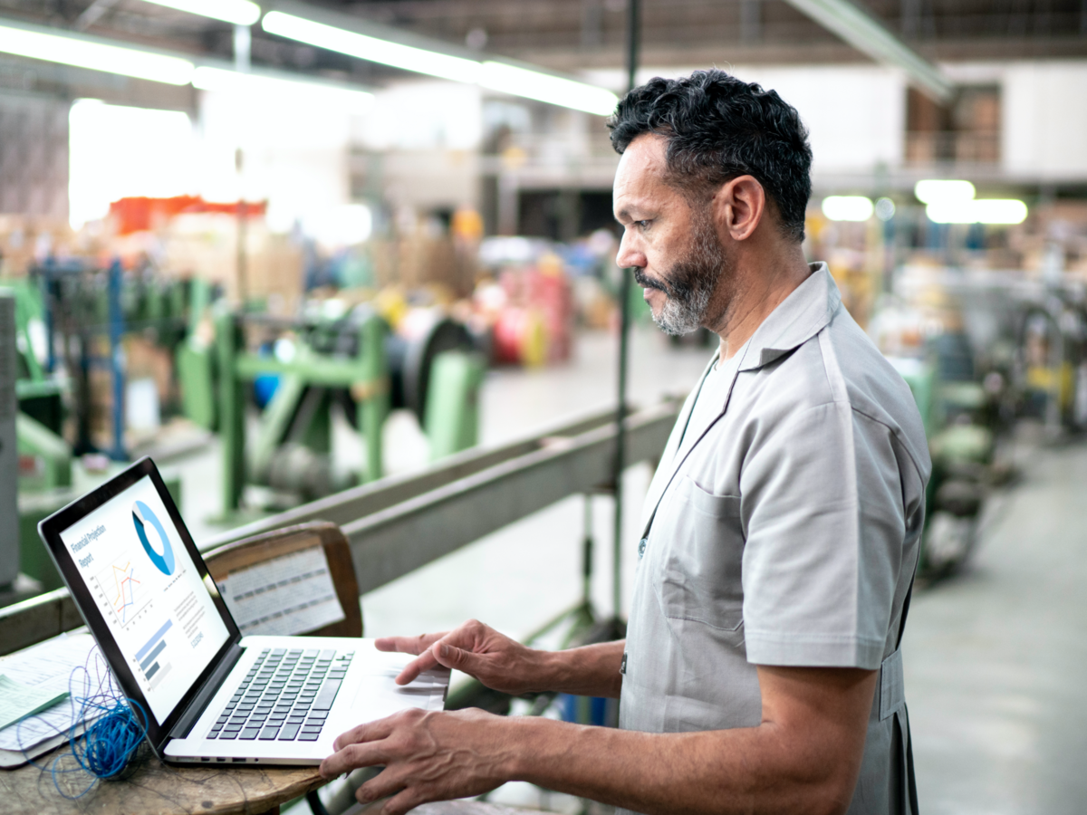 Manufacturer using a laptop on the warehouse floor